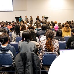 Audience seated in a conference room attending a panel discussion at the 2025 NBCS